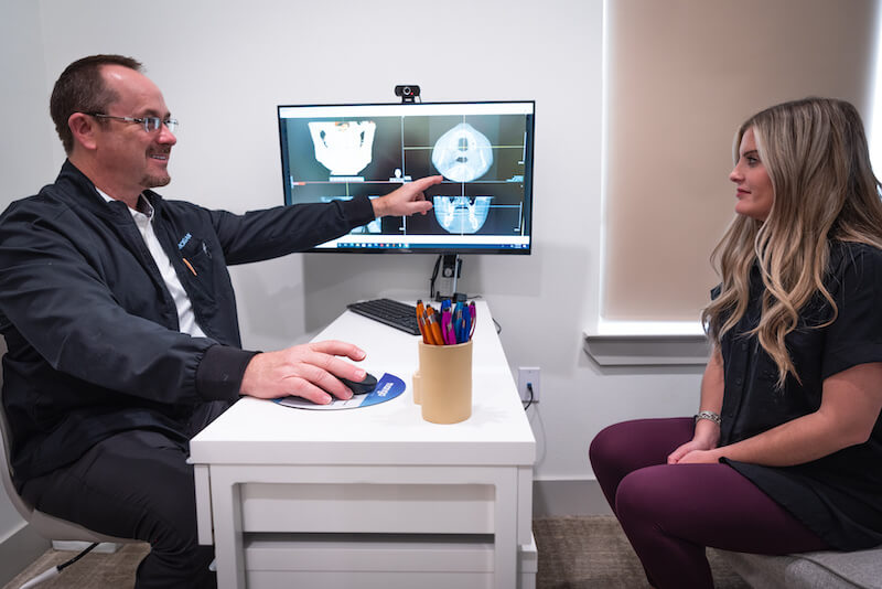 Dr. Davis Morgan talking a patient through their dental scans at Aesthetic & Implant Dentistry of Lubbock